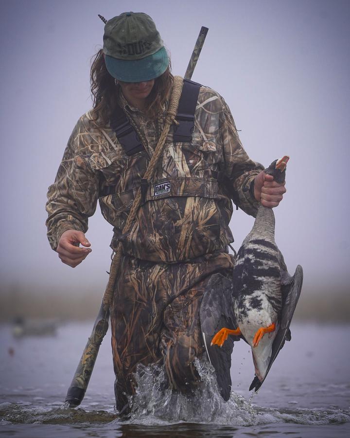 Hunter carrying a specklebelly back to the blind